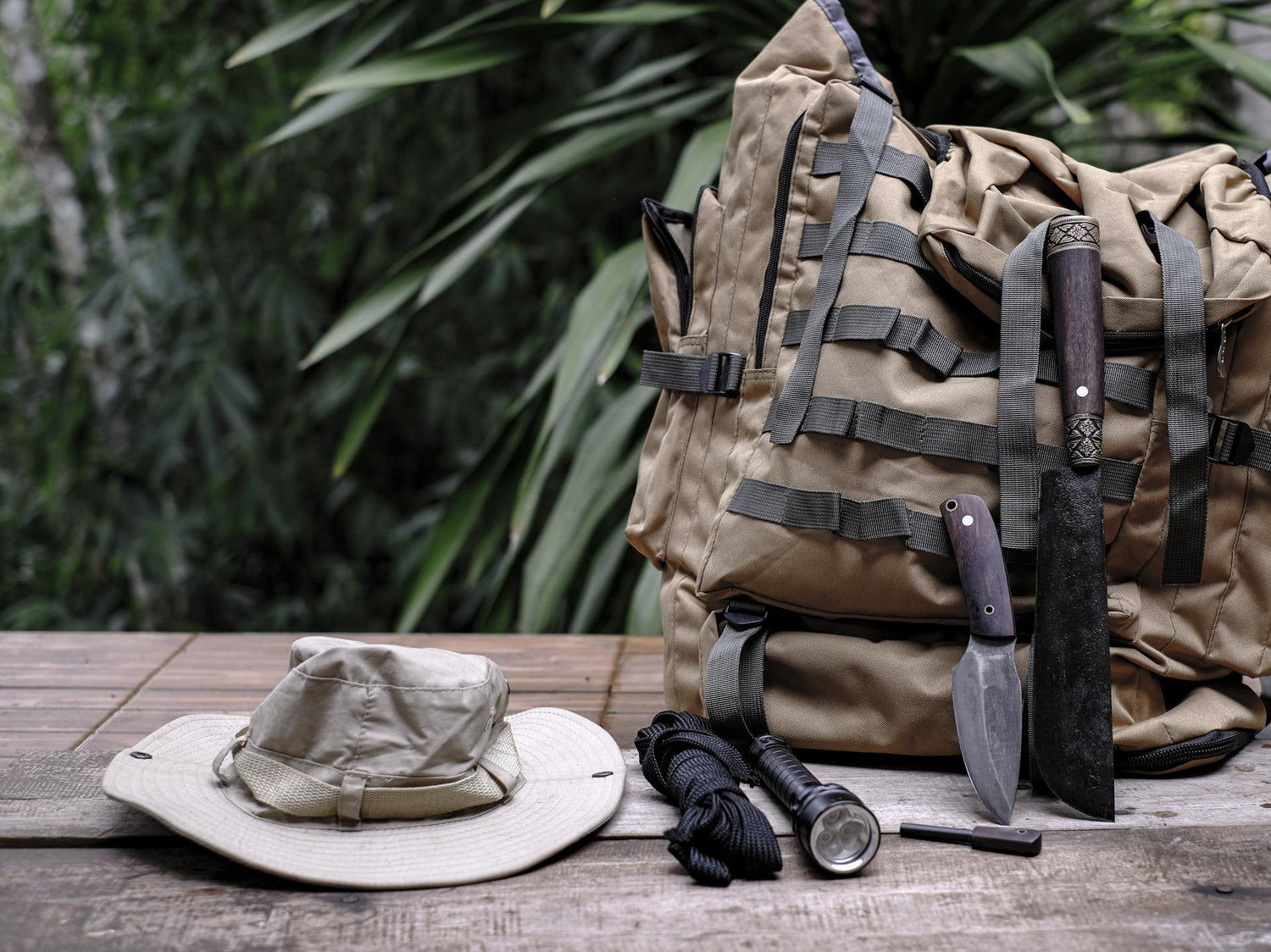 A knife with equipment for survival in the forest  on an old wooden floor