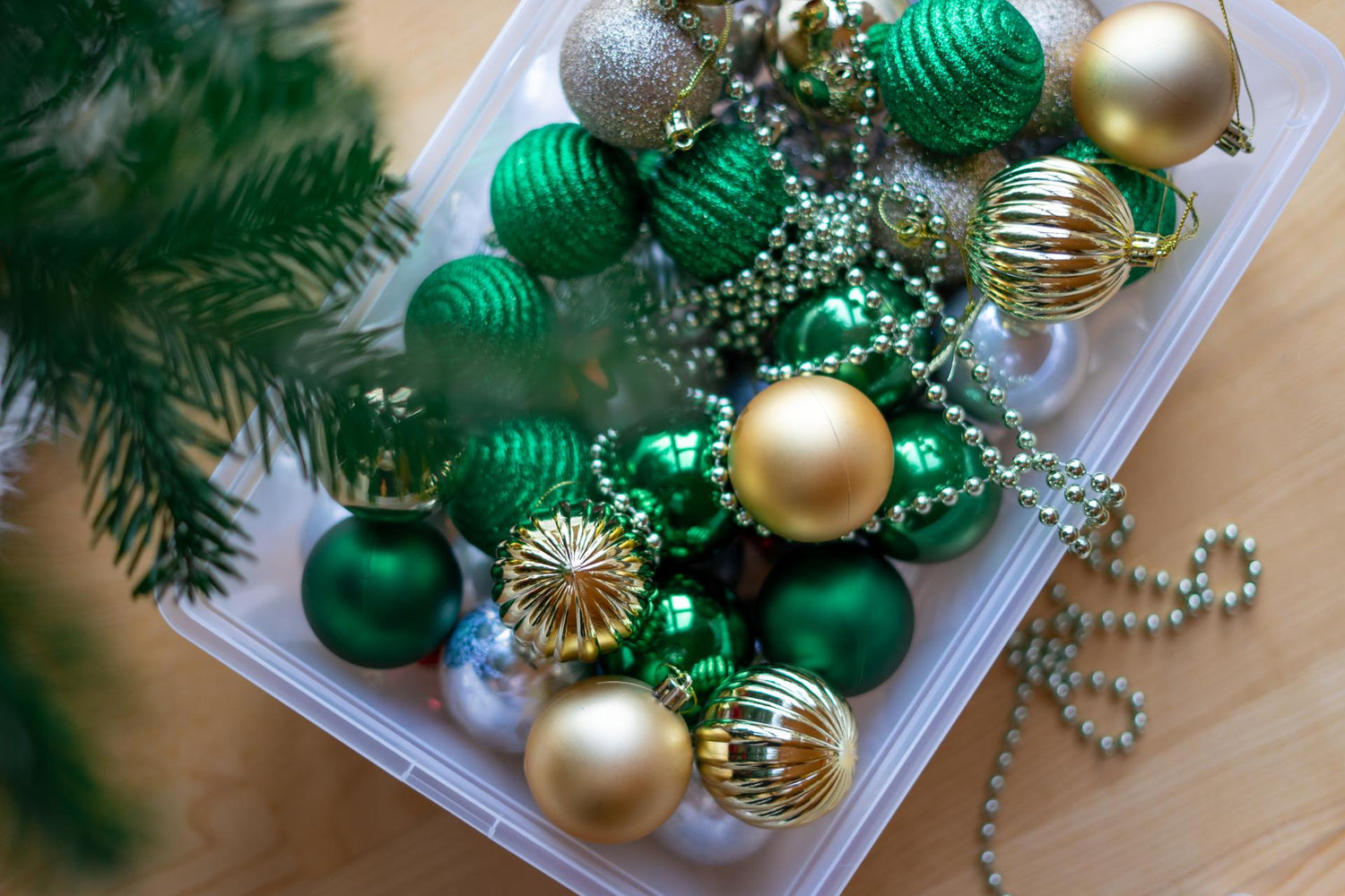 Large plastic box with prepared colorful toys for decorating the Christmas tree before the holidays