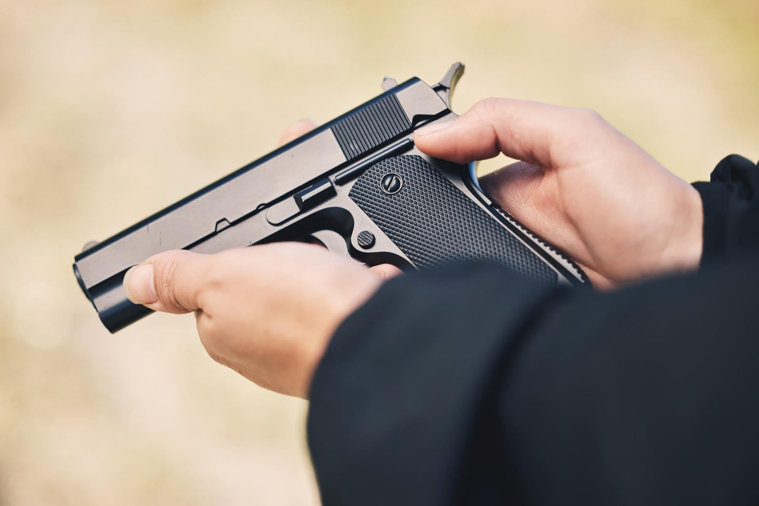 Weapon, pistol and hands with gun outdoor for police, military and safety training at firing range. Security, danger and person holding metal firearm for criminal protection, shooting and fight crime