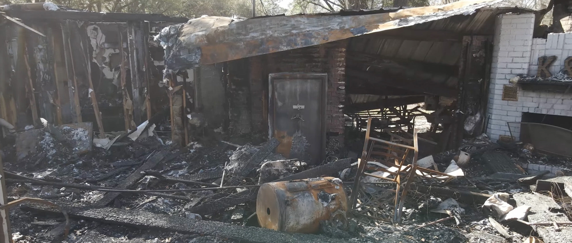 A Liberty Safe still stands in the rubble of a house fire.