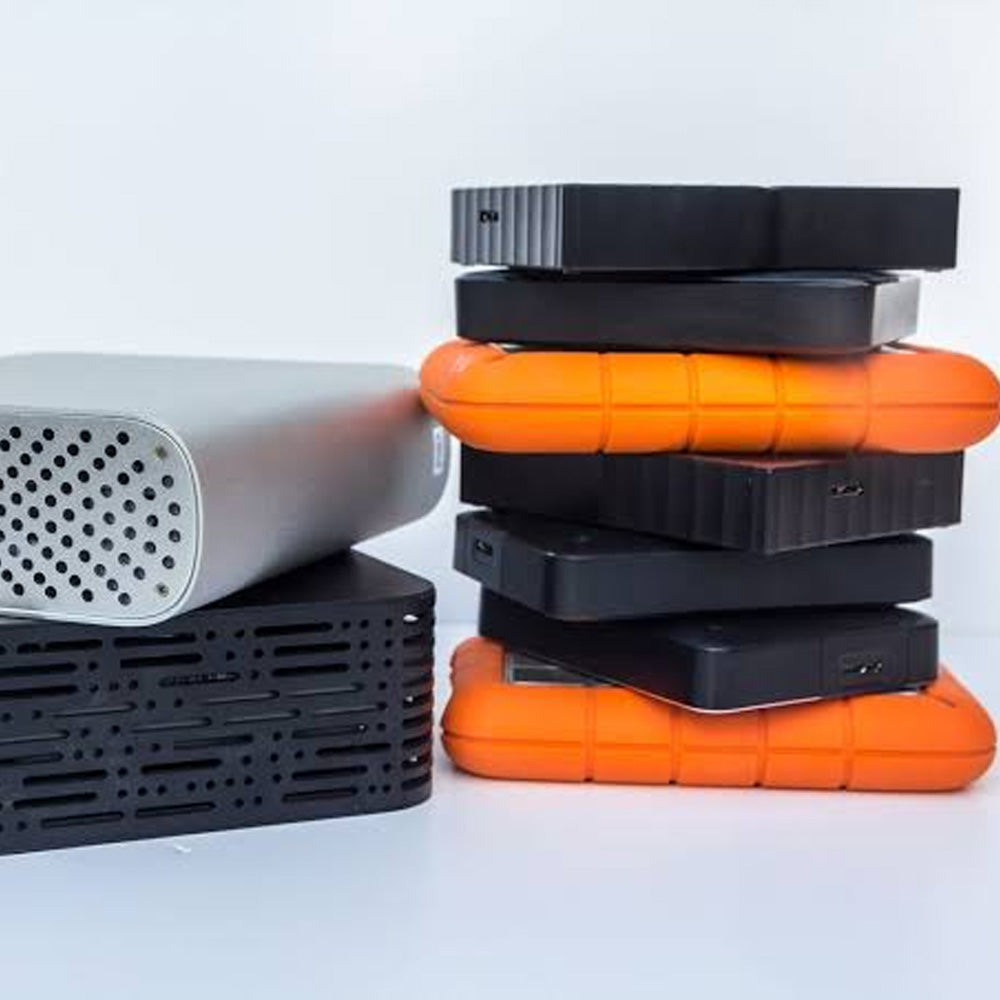 Stacks of hard drives in black, orange, and silver on a white background